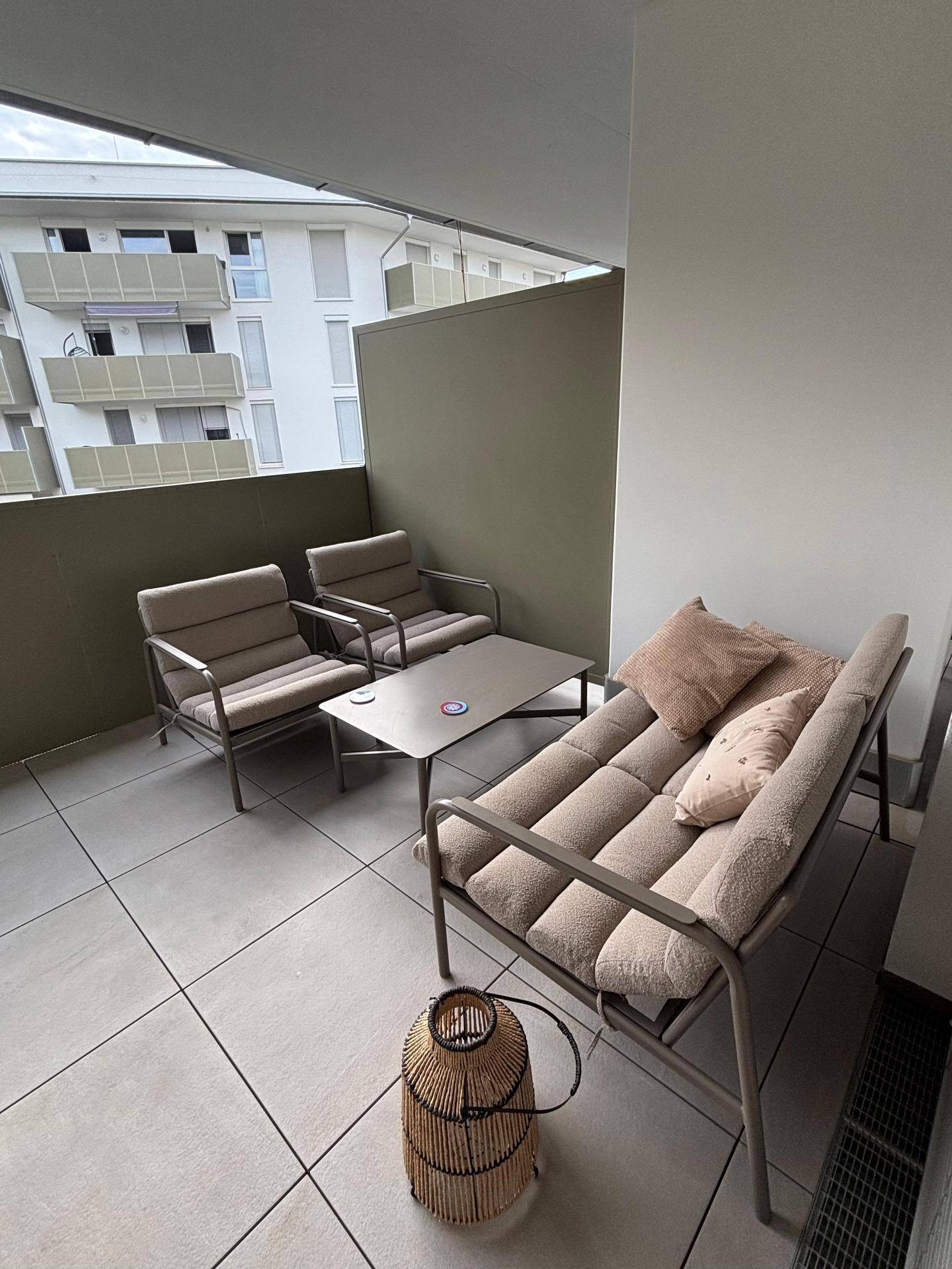 Gemütlicher Balkon mit Sitzgelegenheiten und Blick auf die umliegenden Gebäude.