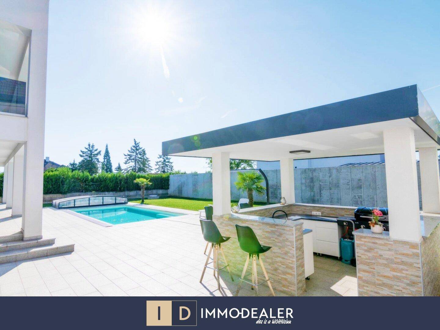 Sonniger Gartenbereich mit Swimmingpool, moderner Außenküche und Bar für gesellige Stunden im Freien.