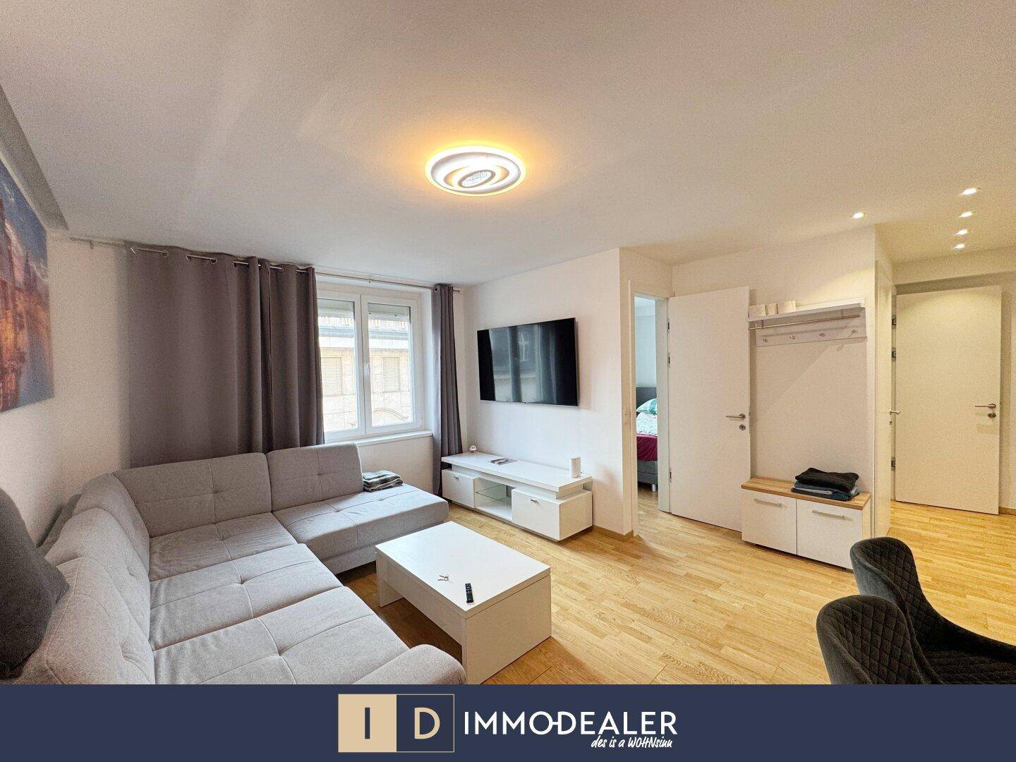 Gemütliches Wohnzimmer mit Ecksofa, Fernseher und hellem Parkettboden in modernem Stil.