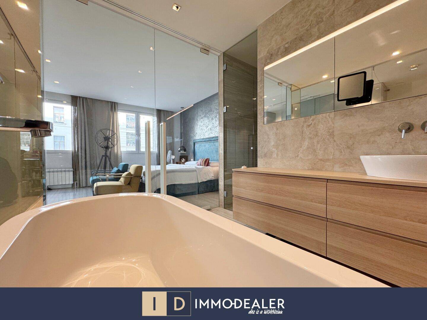 Modernes Badezimmer mit freistehender Badewanne und Blick ins Schlafzimmer.