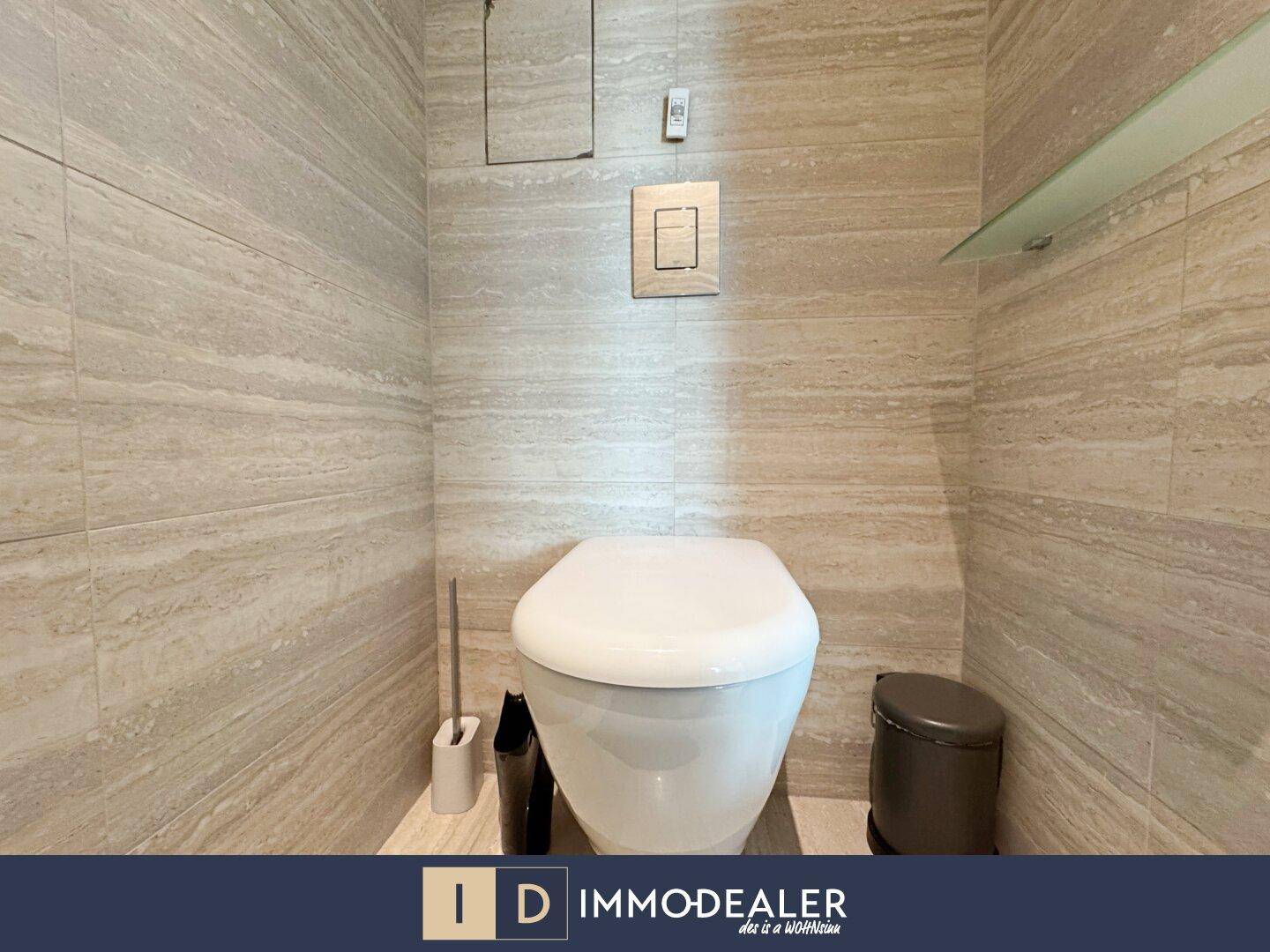 Separate Toilette mit modernen Wandfliesen und wandmontiertem WC.