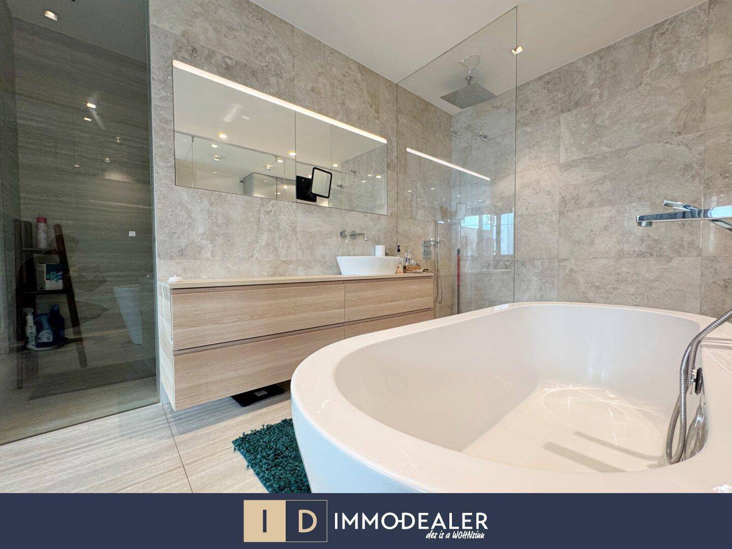 Elegantes Badezimmer mit großer Badewanne, Regendusche und Marmorfliesen.