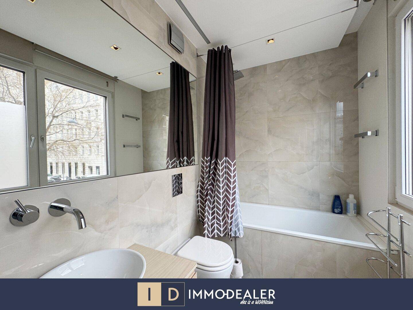 Modernes Badezimmer mit Badewanne, Duschvorhang und großem Spiegel.