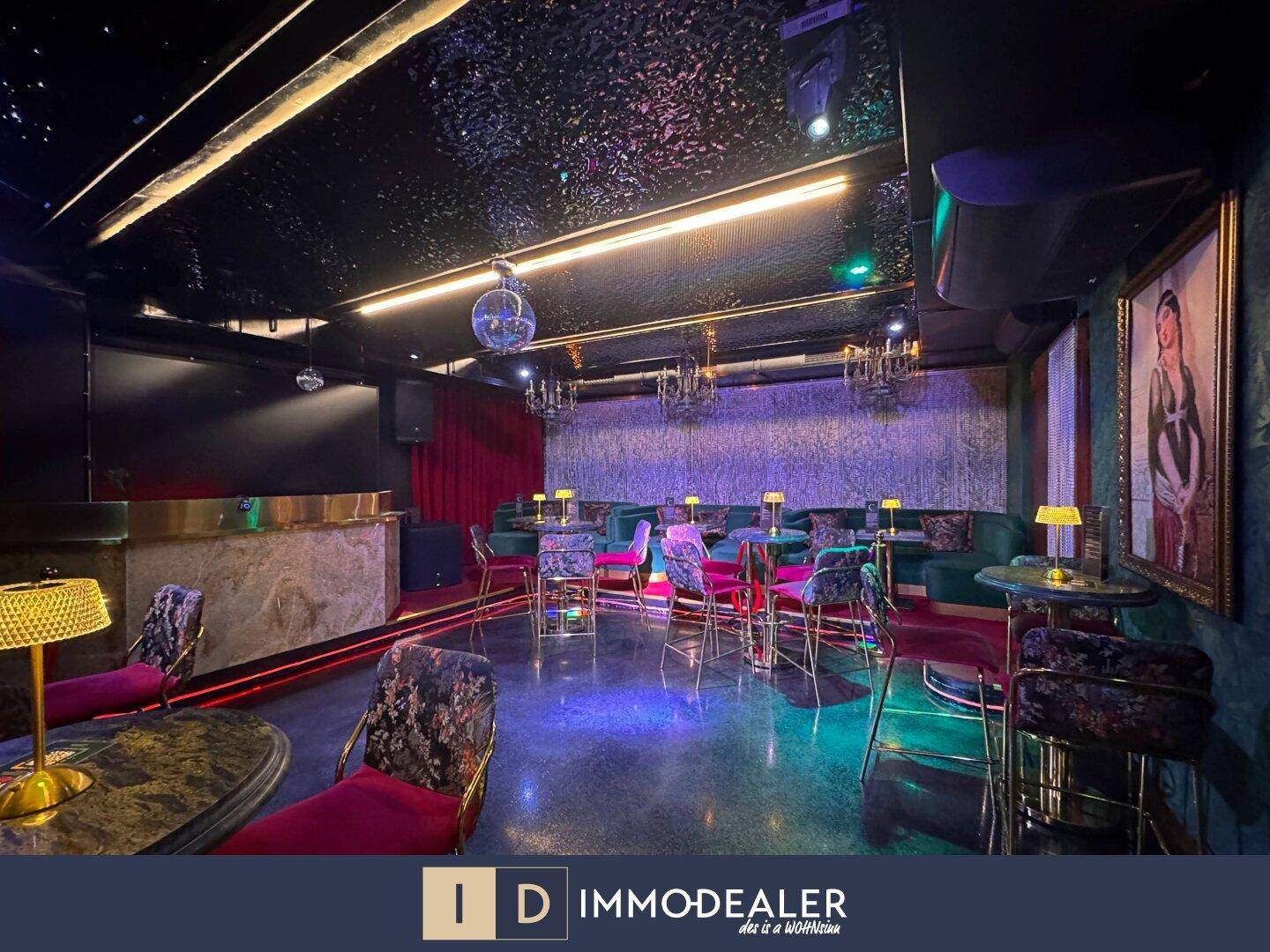 Geräumiger Lounge-Bereich mit verschiedenen Sitzgelegenheiten, einem Discokugel und indirekter Beleuchtung, die eine lebendige Atmosphäre schafft.