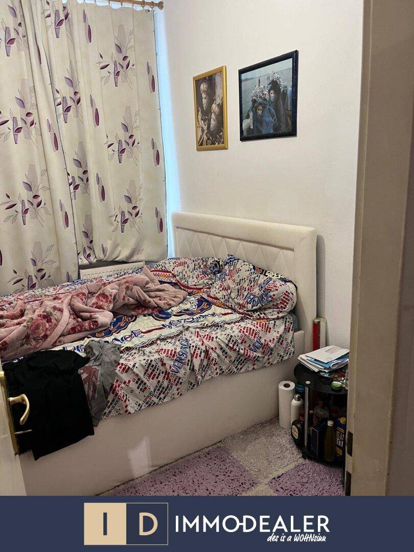 Schlafzimmer mit Bett, gemusterten Vorhängen und Bildern an der Wand, bietet einen privaten Rückzugsort.