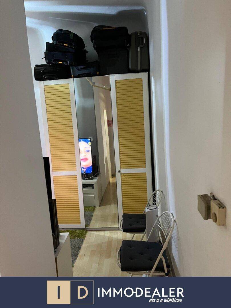 Flur mit Spiegelschrank und Stühlen, bietet Stauraum und einen Blick in den angrenzenden Raum.