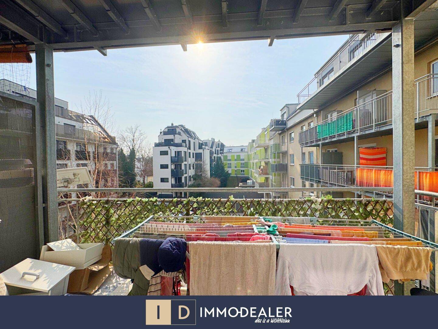 Sonniger Balkon mit Wäscheständer und Blick auf die umliegenden Gebäude.