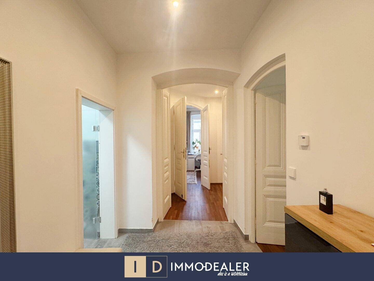 Geräumiger Flur mit Holzboden und eleganten Rundbögen, der zu weiteren Zimmern führt.