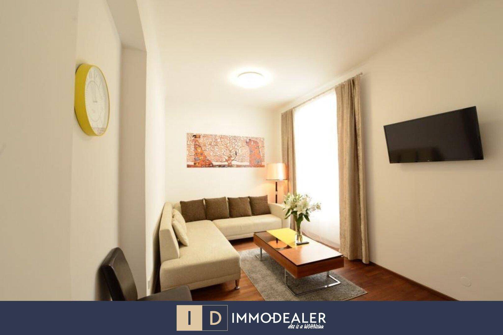 Heller Wohnbereich mit bequemer Couch, Couchtisch und Wandfernseher.