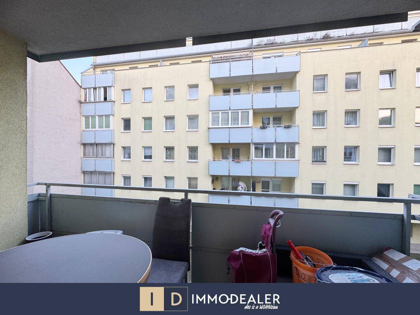 Blick vom Balkon auf ein gegenüberliegendes Wohngebäude mit weiteren Balkonen.