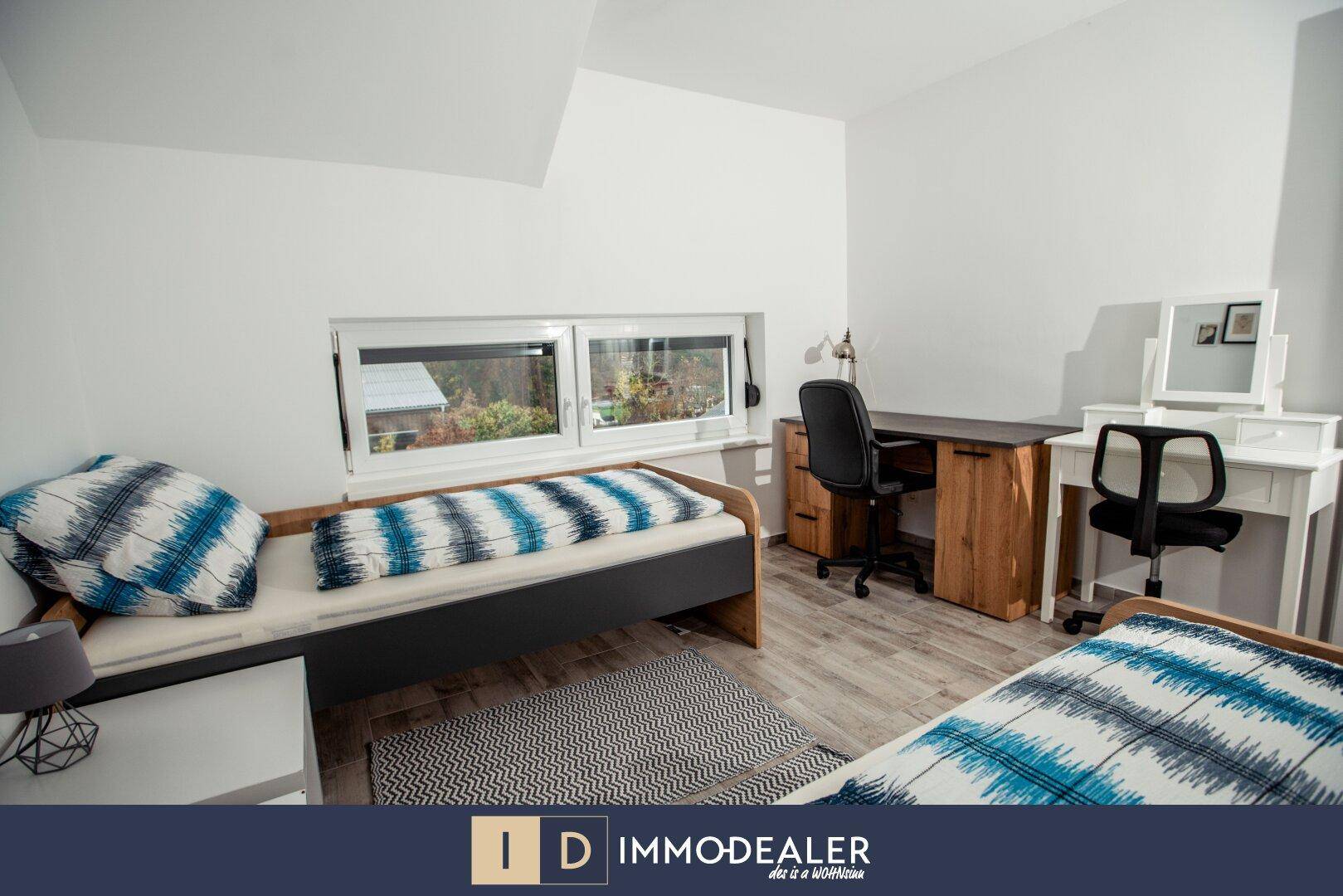Kinder- oder Gästezimmer mit zwei Einzelbetten, Schreibtisch und Fenster mit Ausblick ins Grüne.