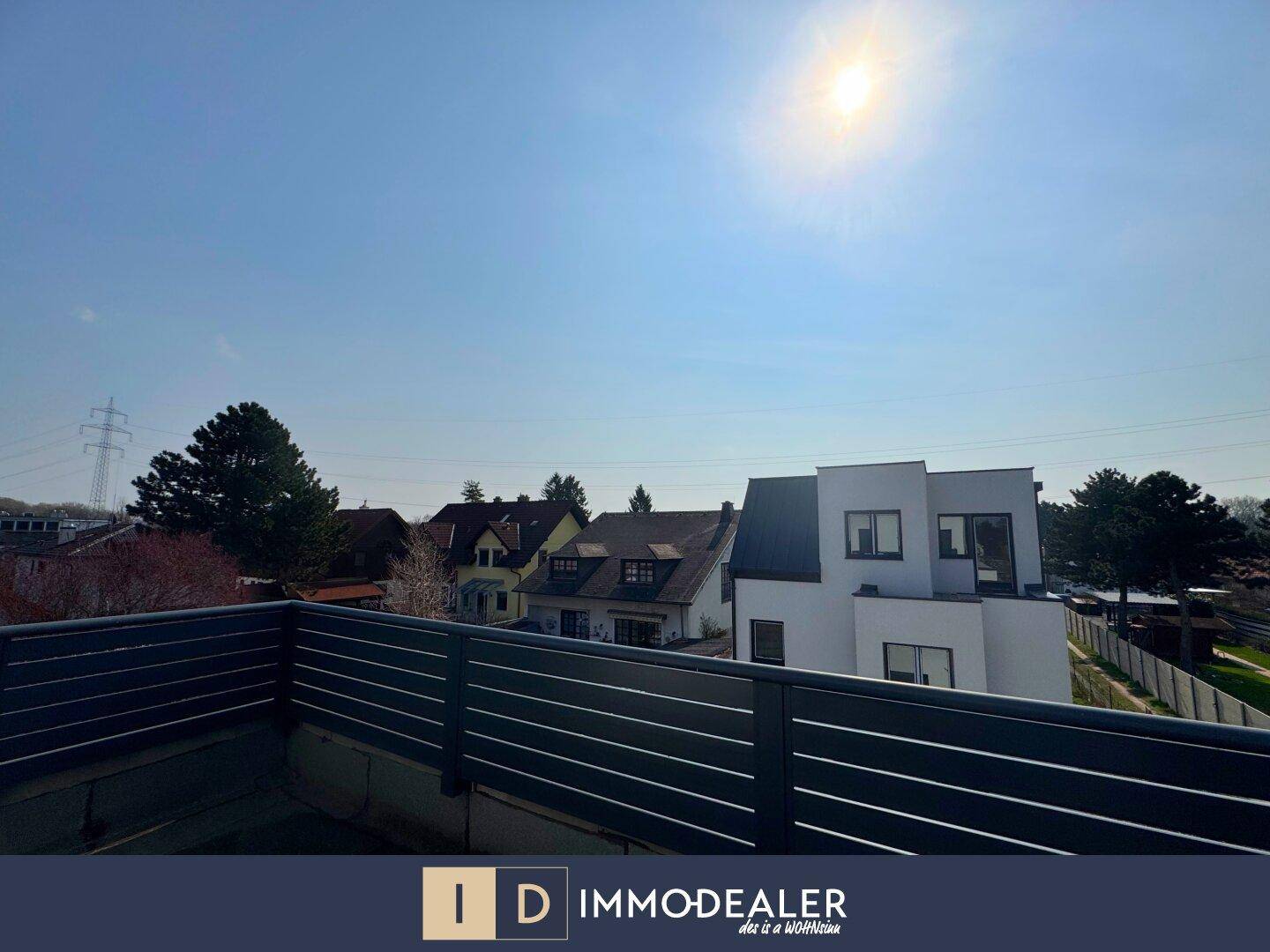 Sonniger Ausblick von einem Balkon auf die umliegende Nachbarschaft und weitere Gebäude.