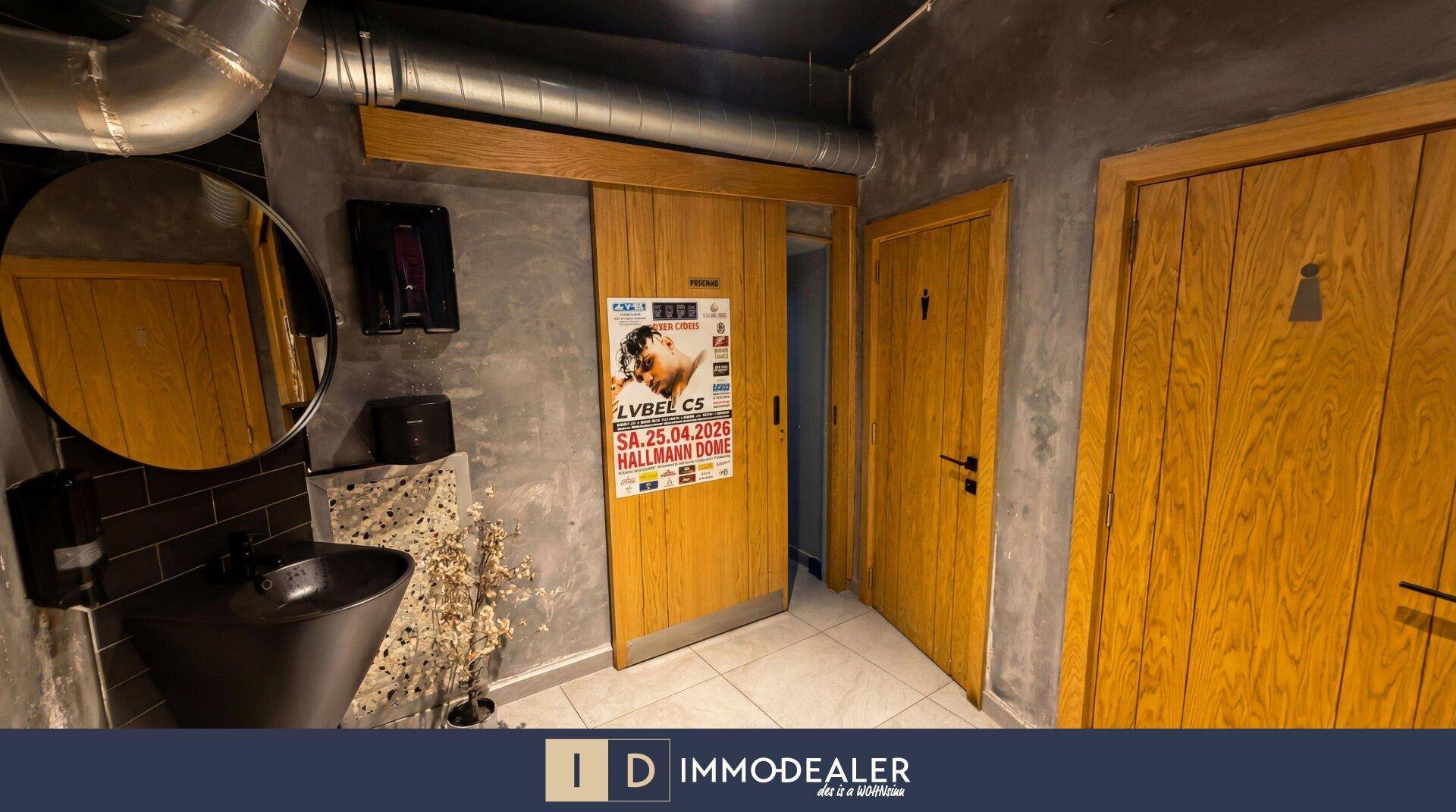 Moderner Toilettenbereich mit Holzschiebetür, Waschbecken und Spiegel, gestaltet im industriellen Stil.
