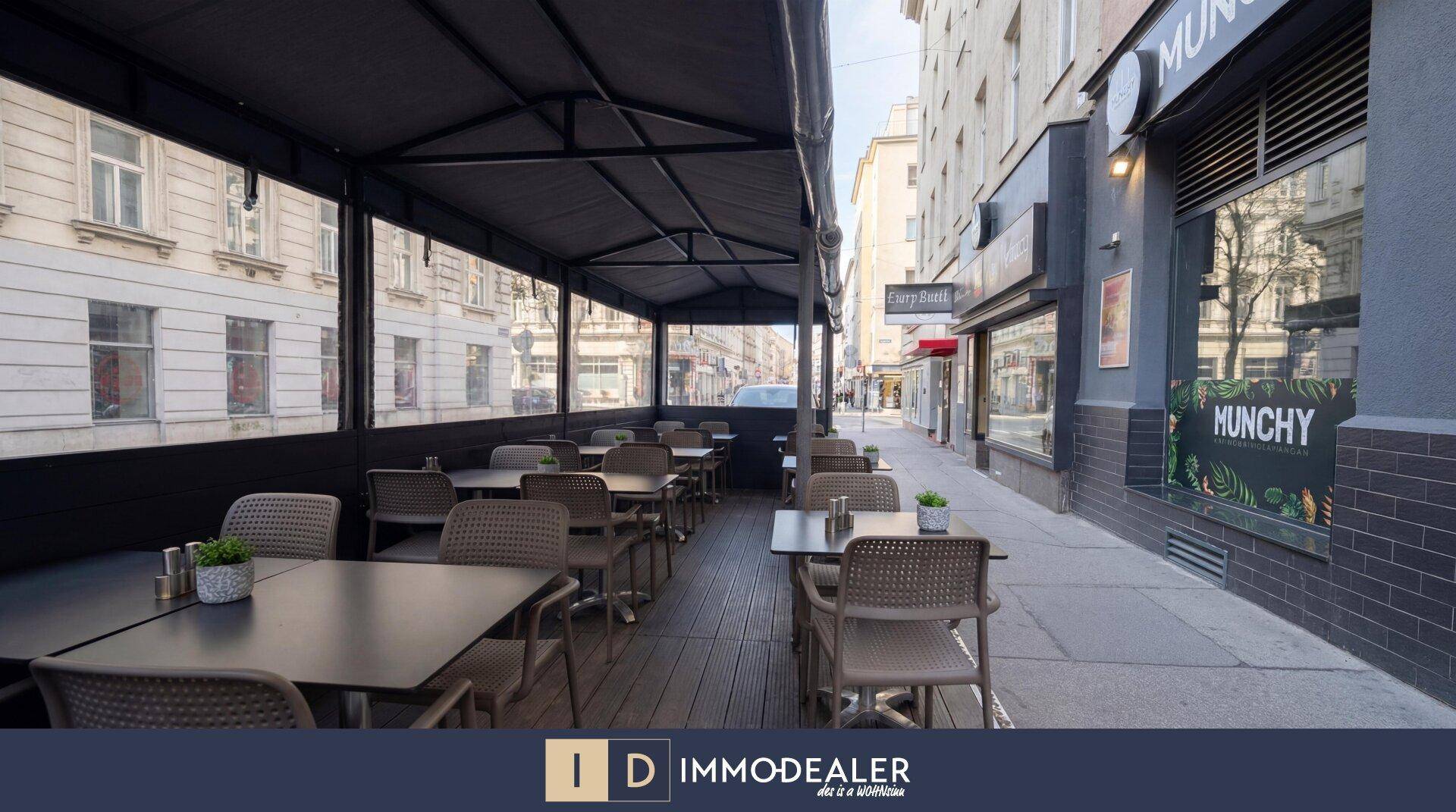 Überdachte Außenterrasse des Restaurants mit zahlreichen Tischen und Stühlen, ideal für Mahlzeiten im Freien.