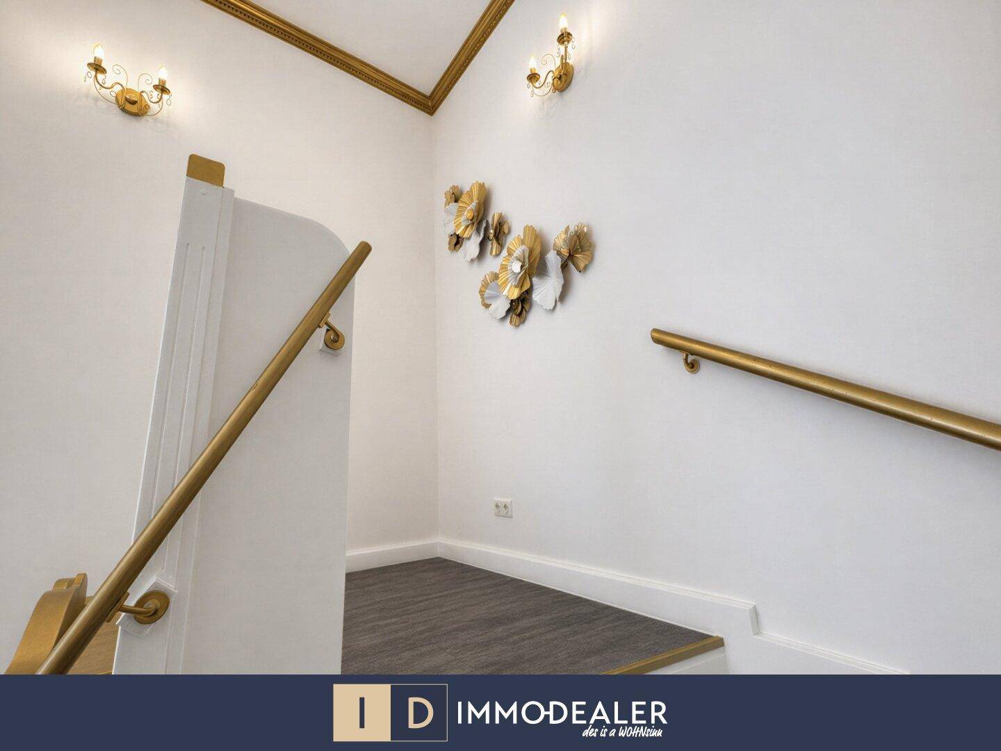 Treppenaufgang mit goldenen Handläufen und dekorativen Wandverzierungen, die den eleganten Stil des Hauses betonen.
