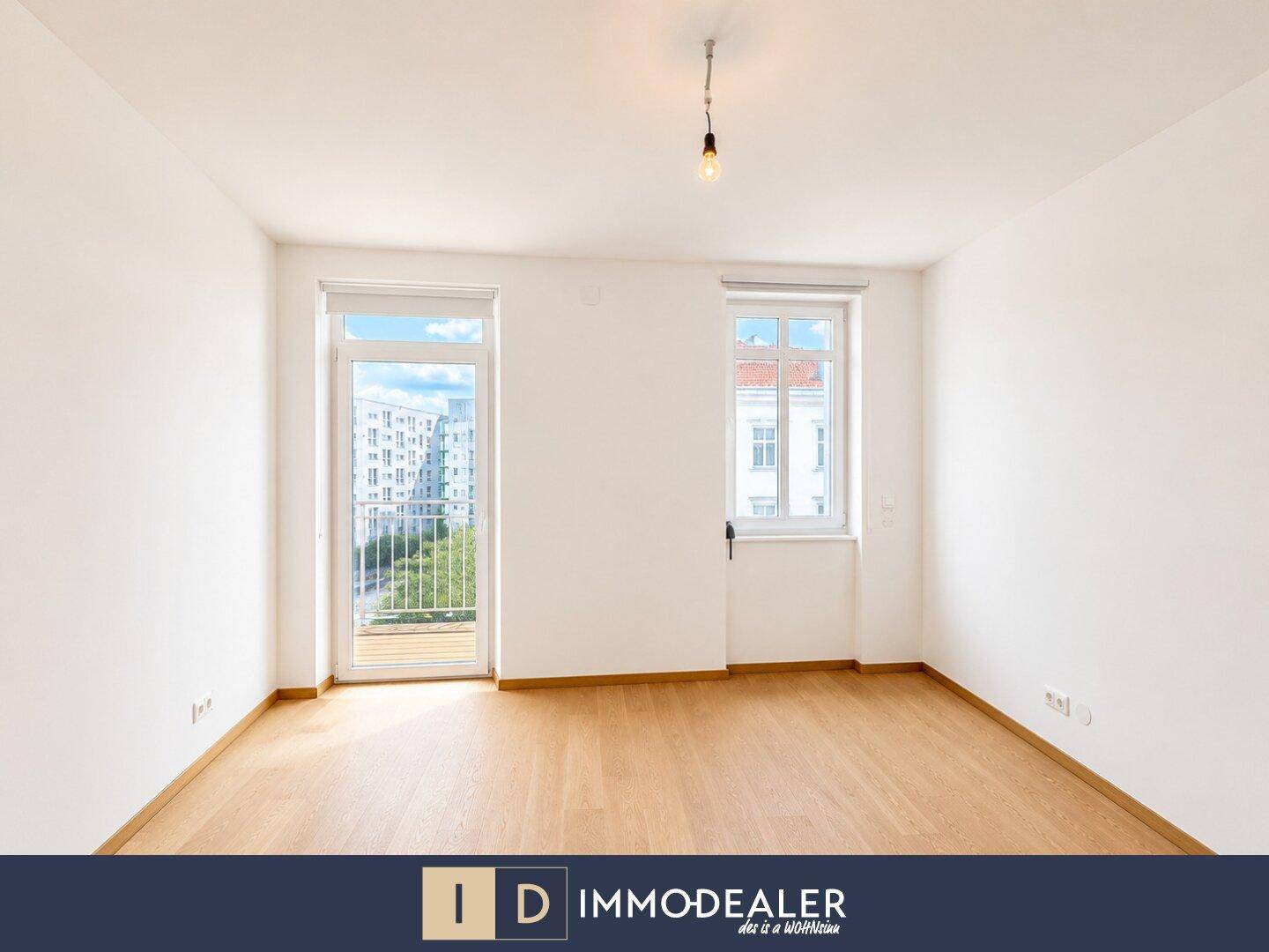 Geräumiges Zimmer mit Parkettboden und großen Fenstern, ideal als Schlaf- oder Arbeitszimmer.