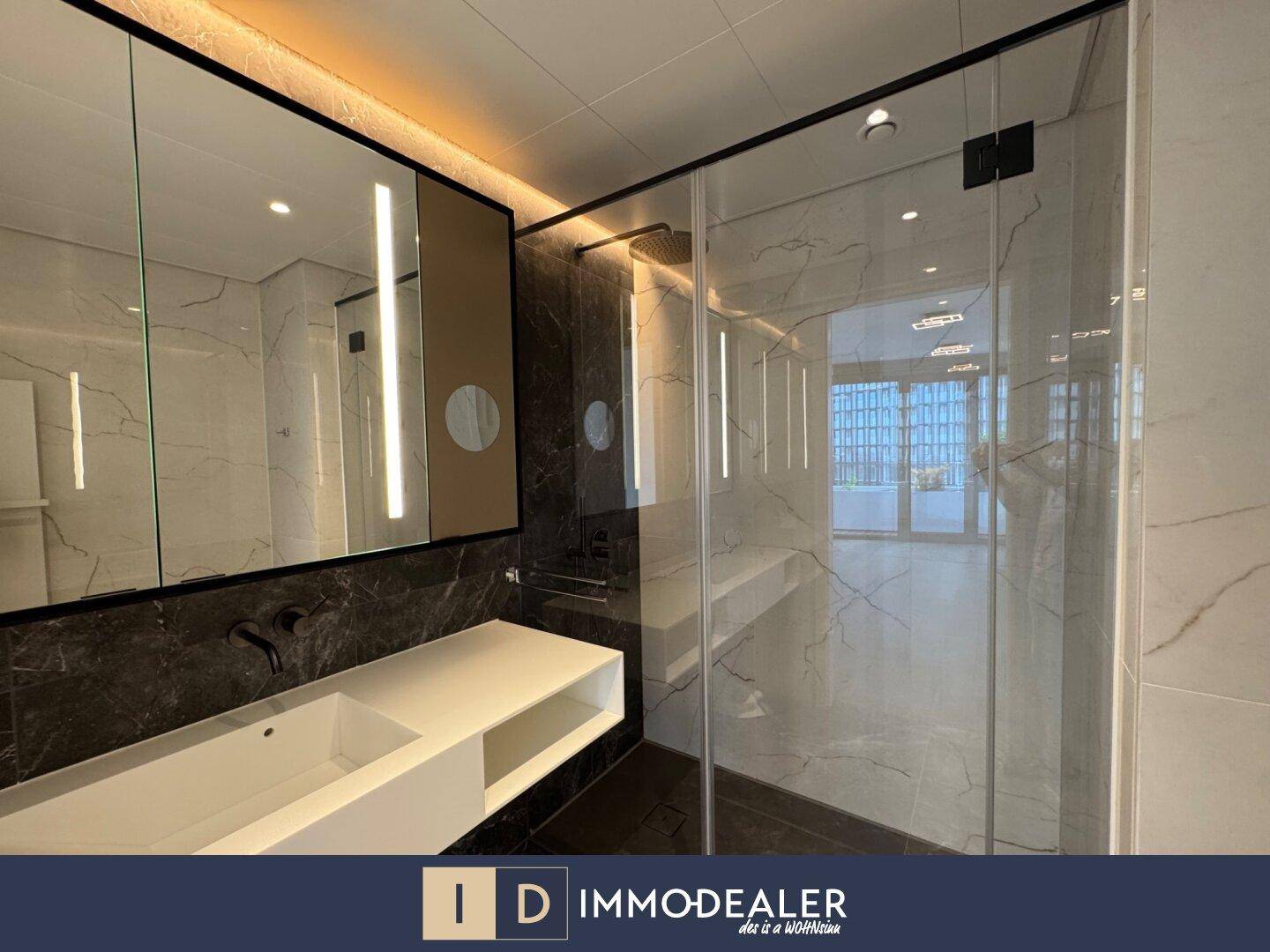 Modernes Badezimmer mit Marmorfliesen, Einzelwaschbecken und einer geräumigen begehbaren Dusche.