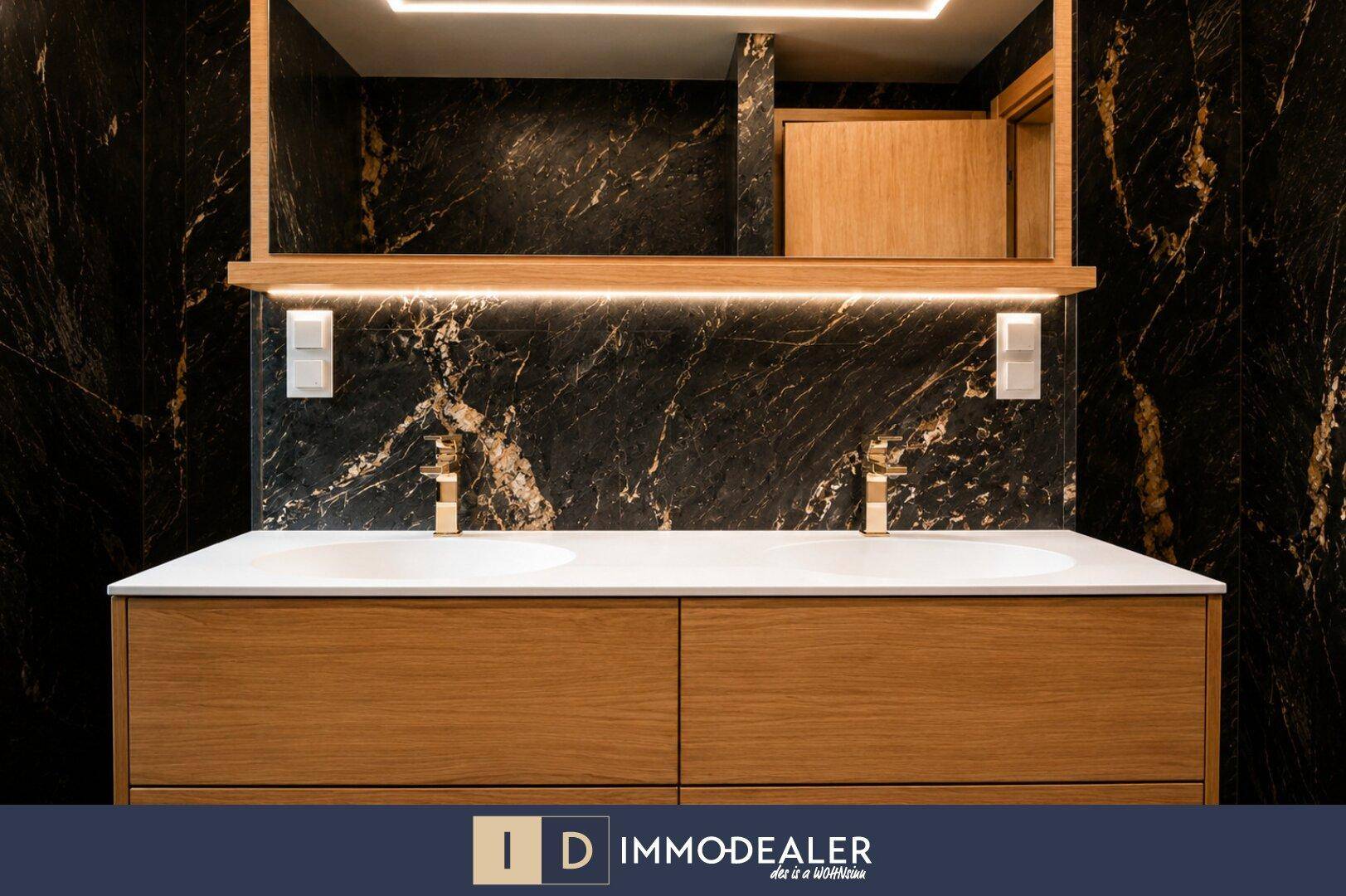 Elegantes Doppelwaschbecken mit modernem Spiegel und indirekter Beleuchtung in einem luxuriösen Bad.