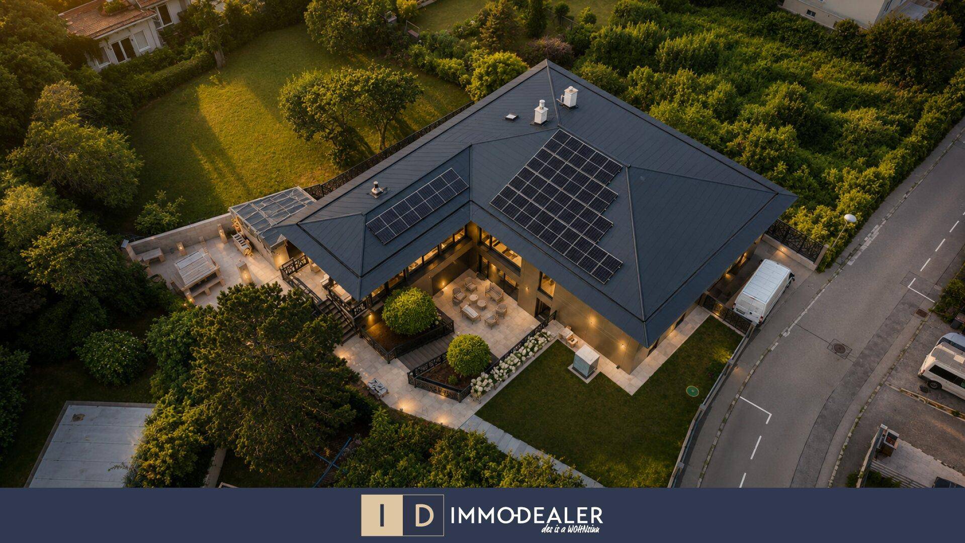Luftaufnahme des modernen Anwesens mit weitläufigem Garten und Solaranlagen auf dem Dach.