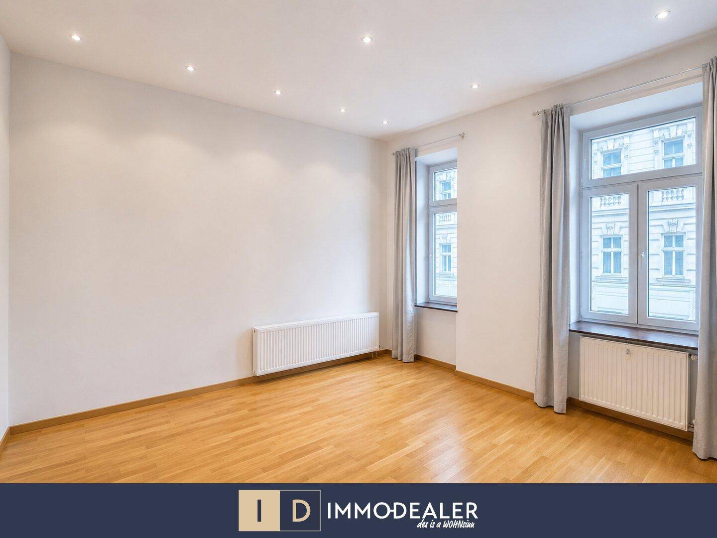 Helles Schlafzimmer mit Parkettboden und zwei Fenstern, bietet eine angenehme Wohnatmosphäre.