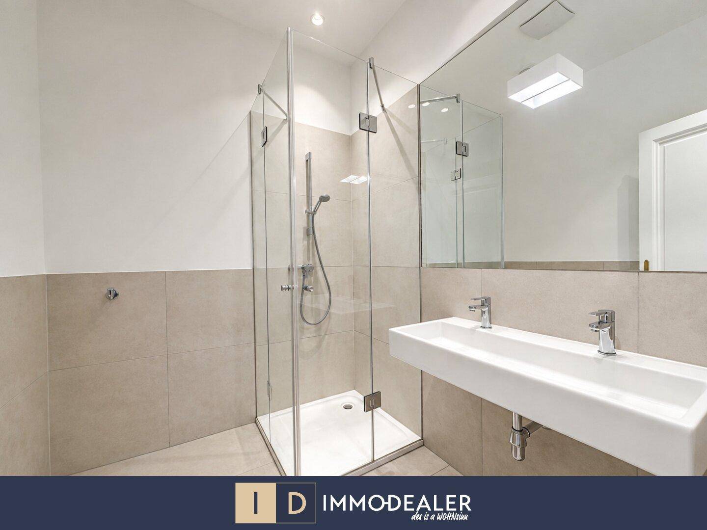 Modernes Badezimmer mit begehbarer Dusche, Doppelwaschbecken und hellen Fliesen.