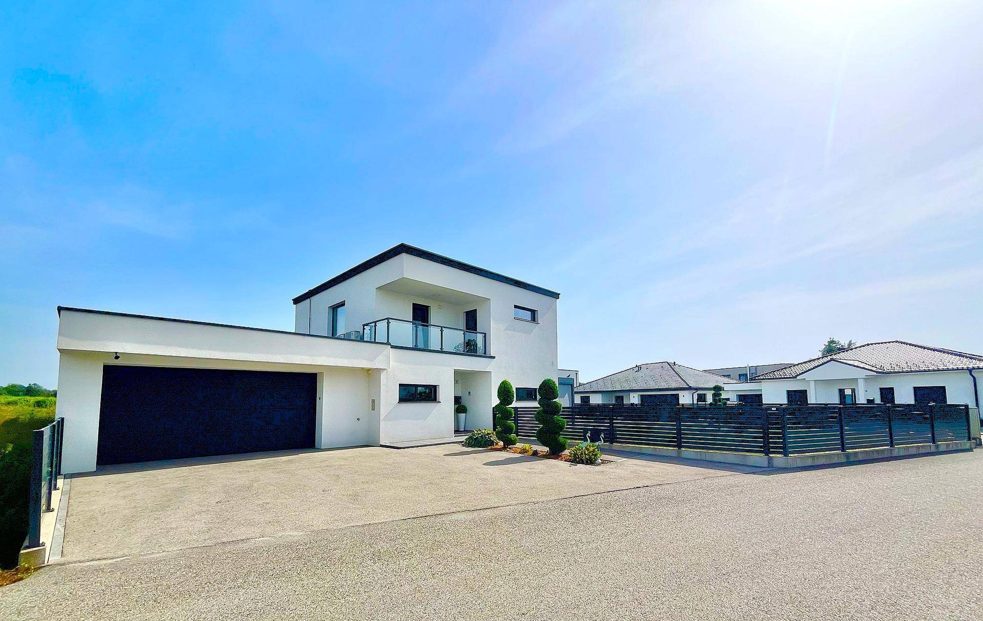 Freistehendes modernes Haus mit Doppelgarage und gepflegtem Vorgarten.
