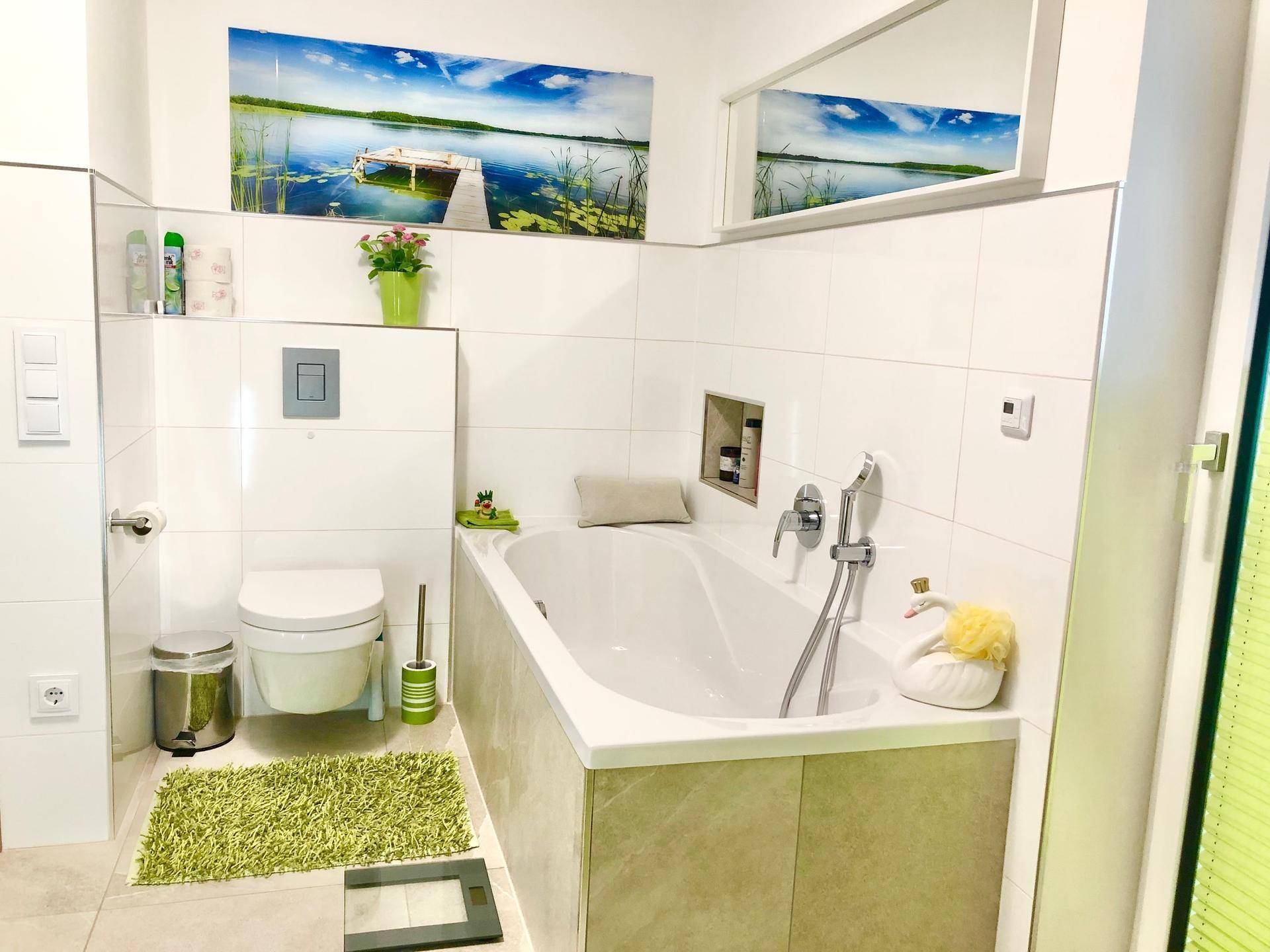 Helles Badezimmer mit Badewanne, Wand-WC und modernem Design.