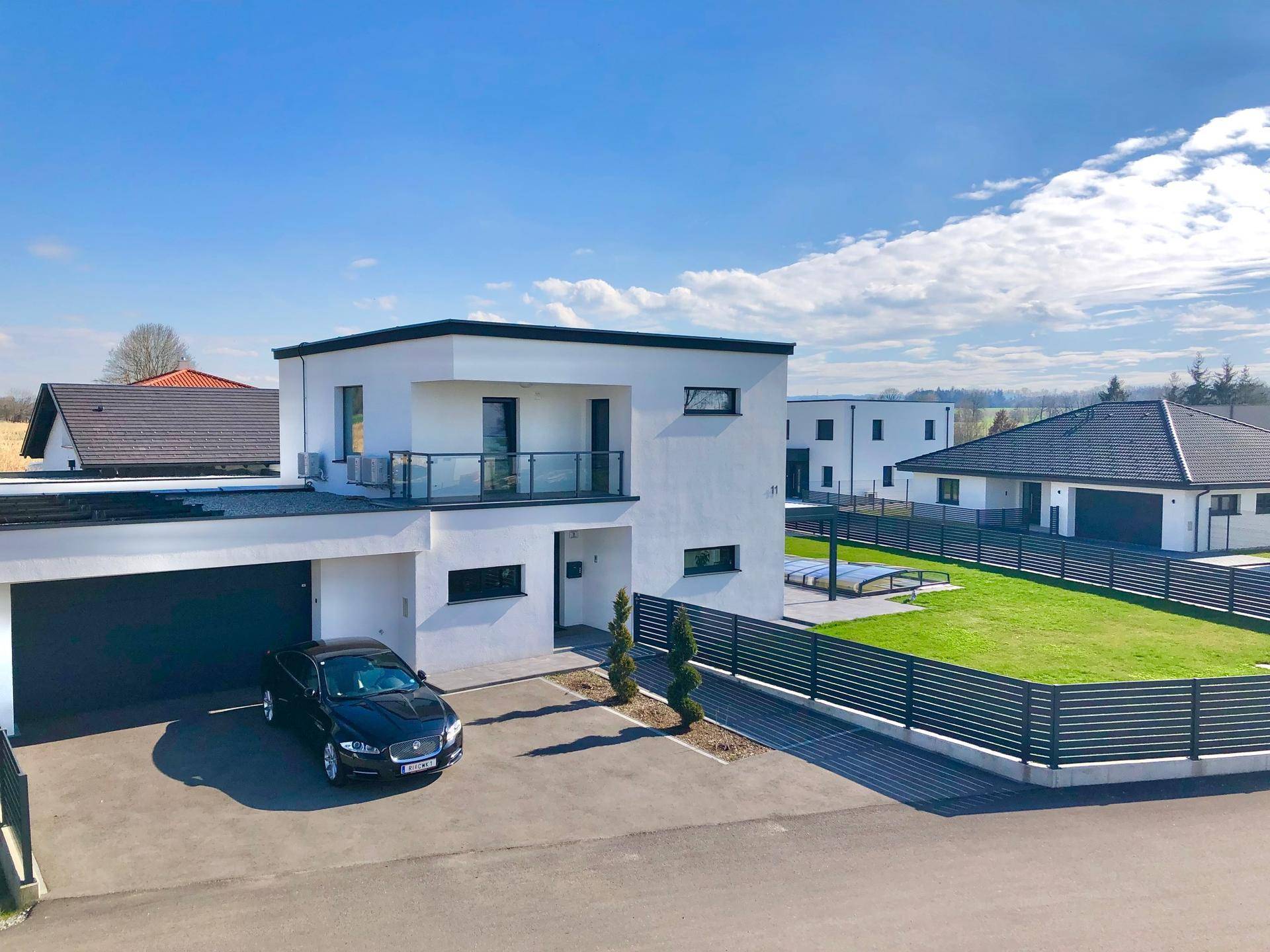 Moderne Wohnanlage mit Einfamilienhäusern, großem Garten und Poolbereich.