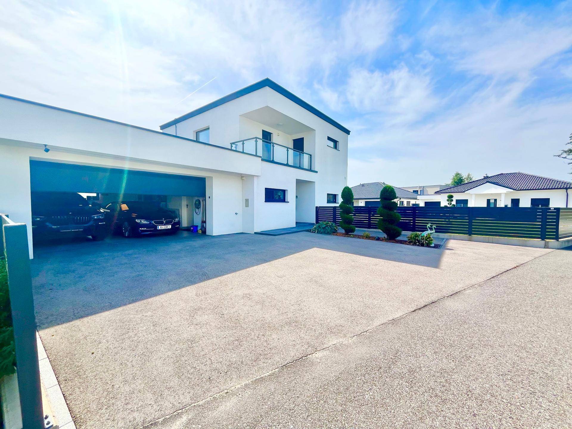 Modernes Haus mit großer Auffahrt, Doppelgarage und gepflegter Außenanlage.