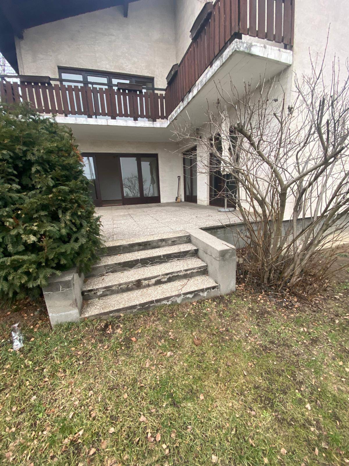 Außenterrasse mit Steinstufen und Zugang zum Gartenbereich des Hauses.