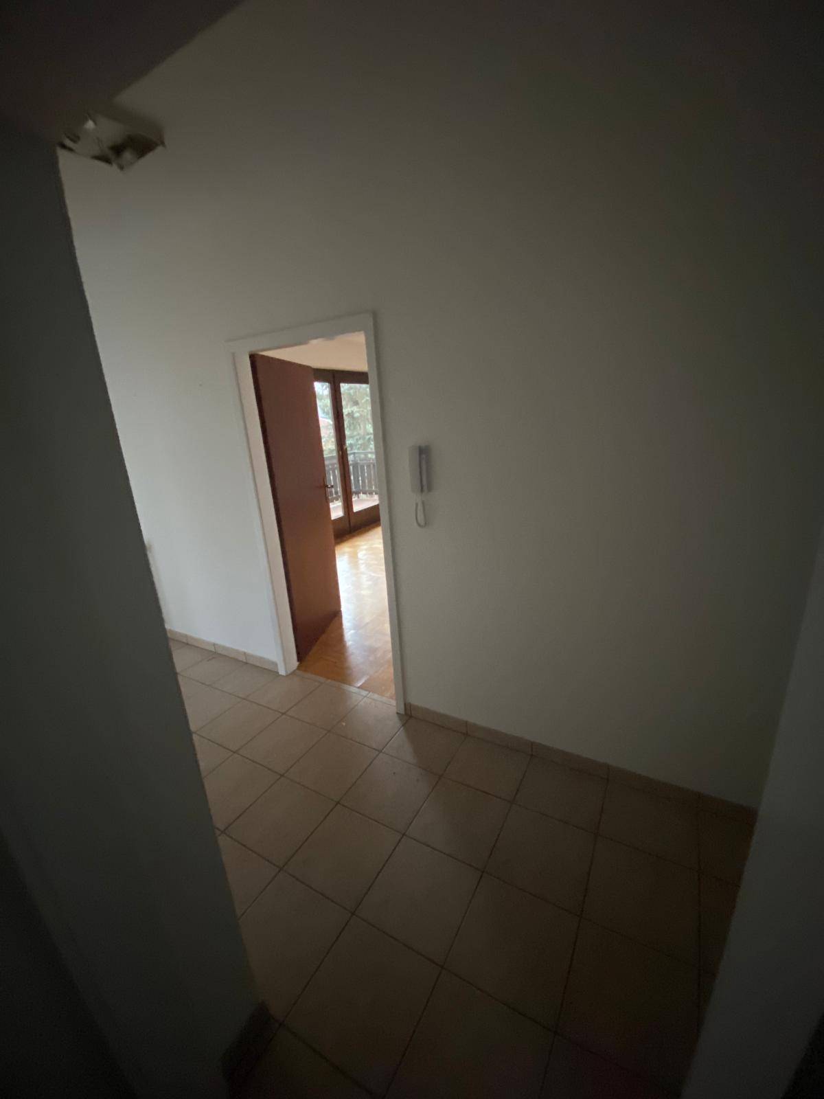 Eingangsbereich mit Fliesenboden und Blick in angrenzende Zimmer.