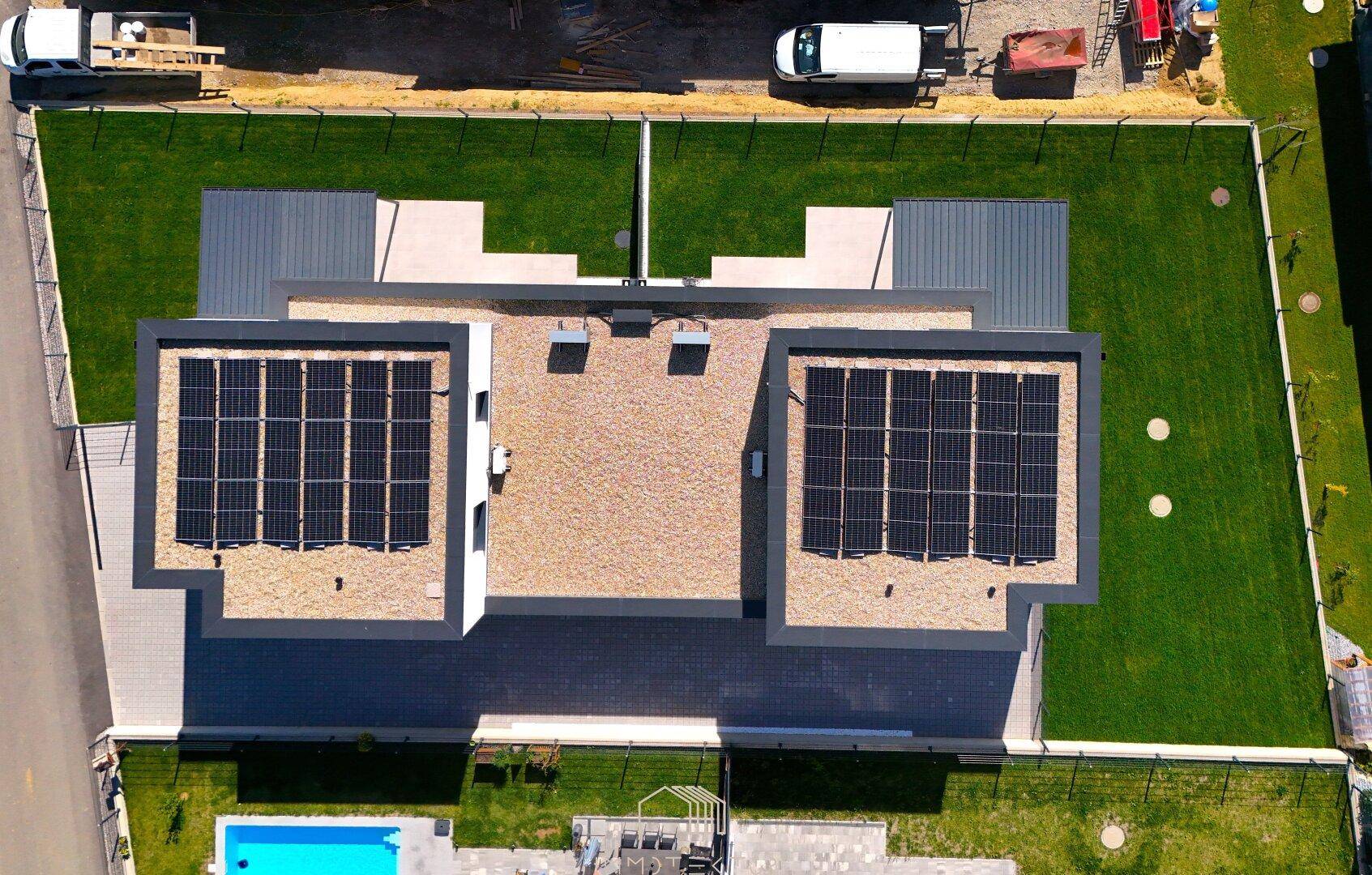 Dachansicht eines modernen Hauses mit Photovoltaikanlage und flachem Dach.
