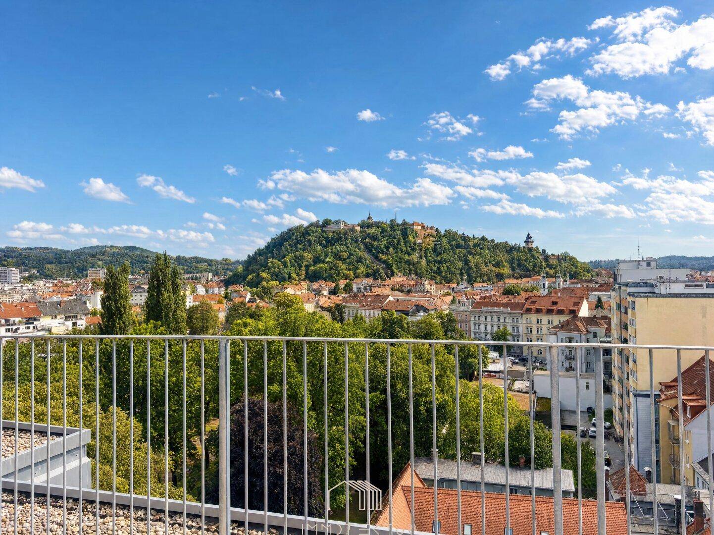 Geräumige Dachterrasse mit weitem Blick über die Stadt und den grünen Schlossberg.