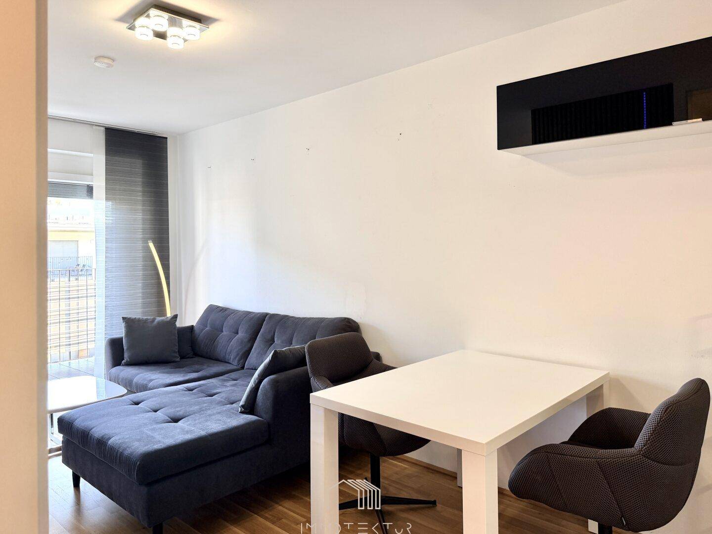 Wohnbereich mit bequemer Couch und Essplatz für zwei Personen.
