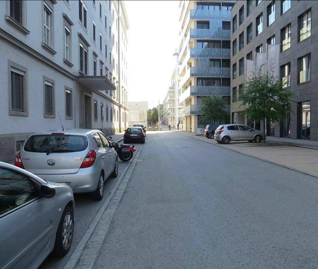 Blick auf eine städtische Straße mit einer Mischung aus modernen und älteren Gebäuden.