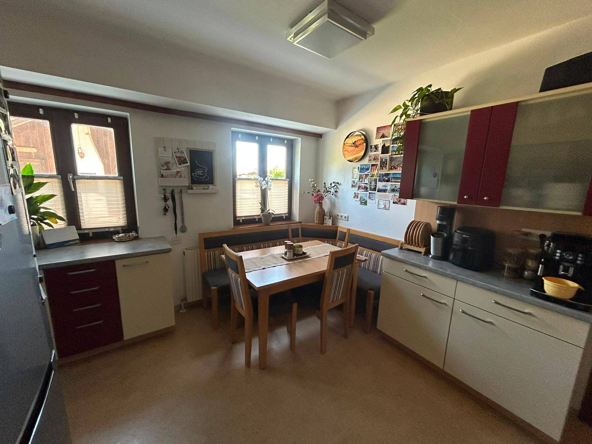 Gemütlicher Essbereich in der Küche mit Holztisch, Eckbank und Fenstern für natürliches Licht.