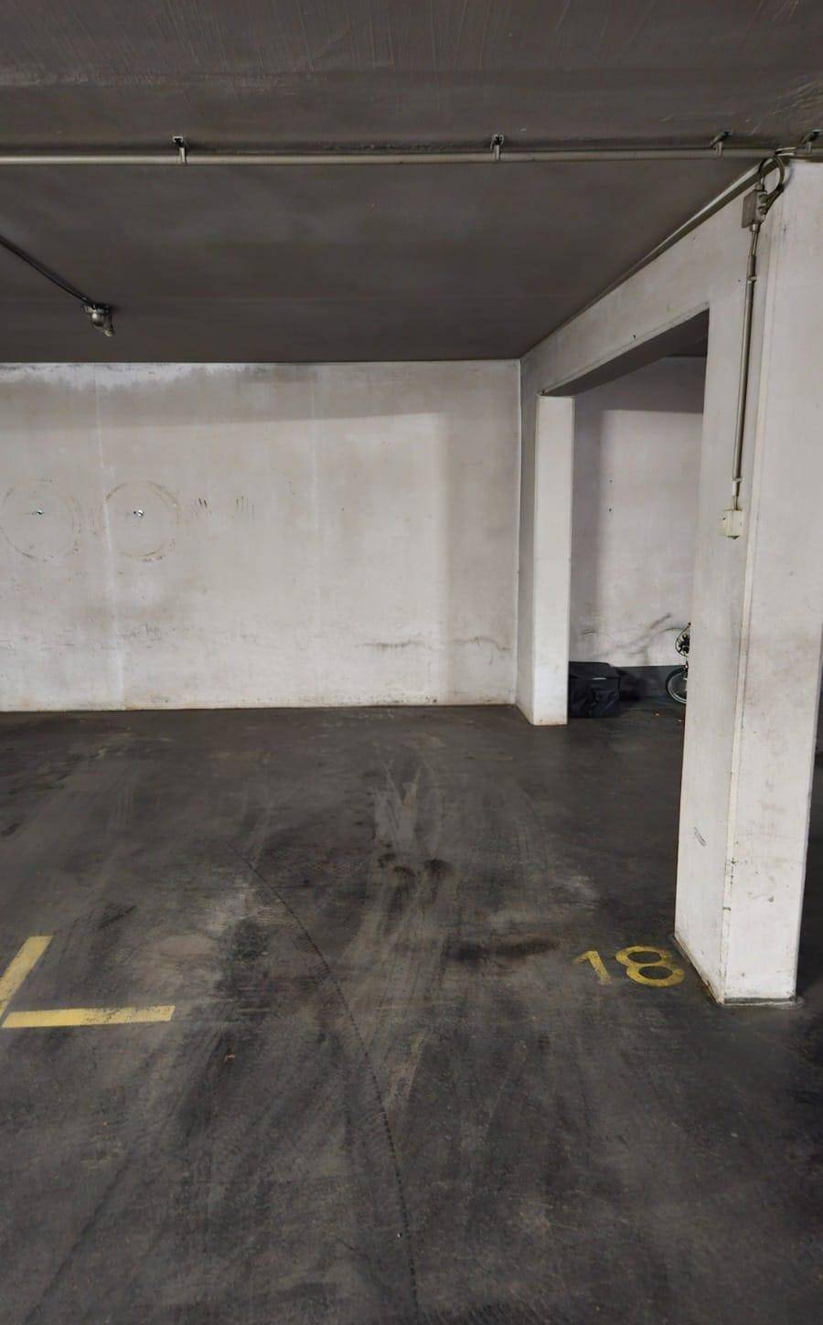 Tiefgarage mit Betonboden und Säulen, bietet sichere Parkmöglichkeiten für Fahrzeuge.