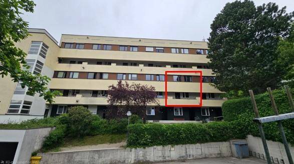 Ansicht des Apartmentgebäudes von außen, umgeben von Bäumen und grüner Landschaft.