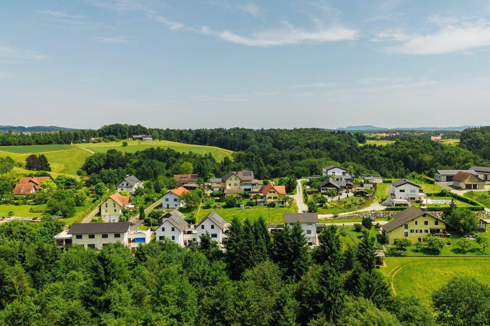Panoramablick aus der Vogelperspektive auf eine idyllische Wohngegend mit vielen Grünflächen.