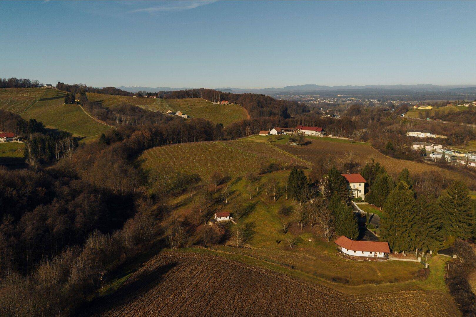 Weitläufige Landschaftsaufnahme des Anwesens mit Blick auf die umliegende Natur und eine entfernte Stadt.
