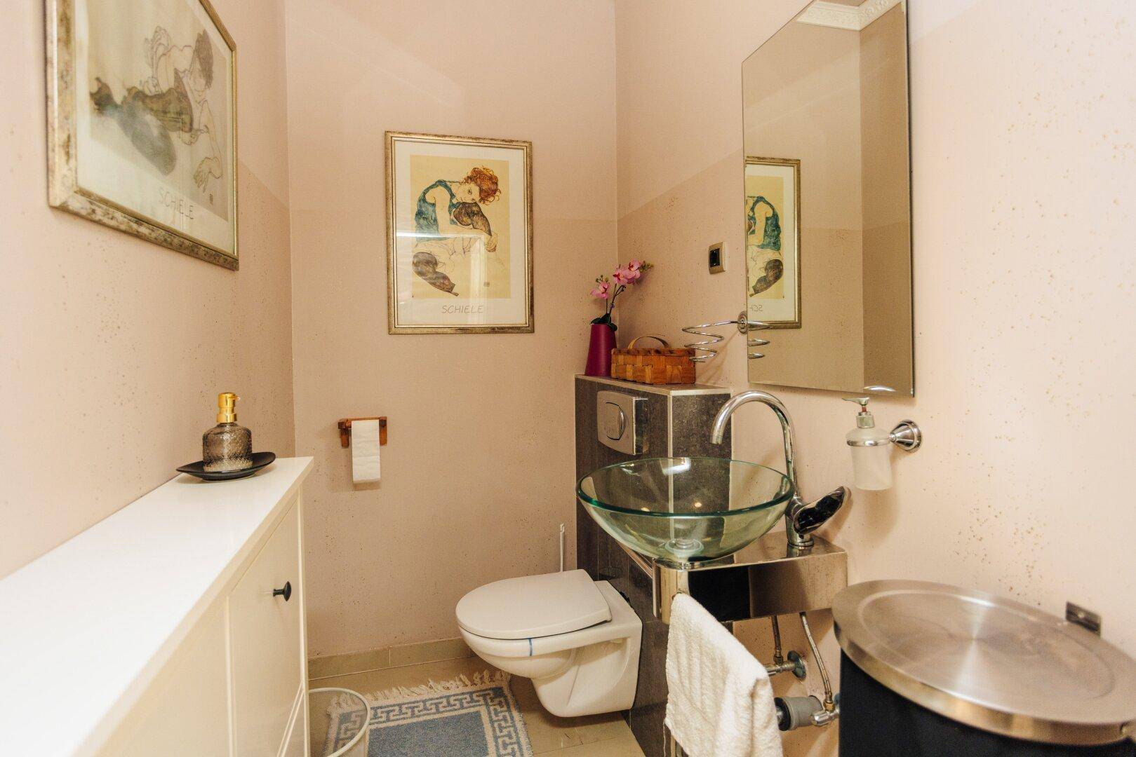 Modernes Gäste-WC mit stilvollem Waschbecken und wandhängender Toilette.