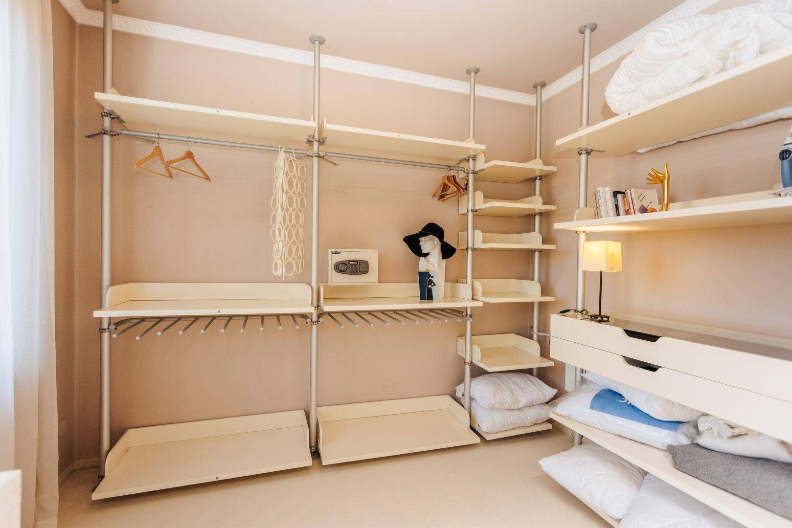 Begehbarer Kleiderschrank mit Regalen, Kleiderstangen und viel Stauraum.