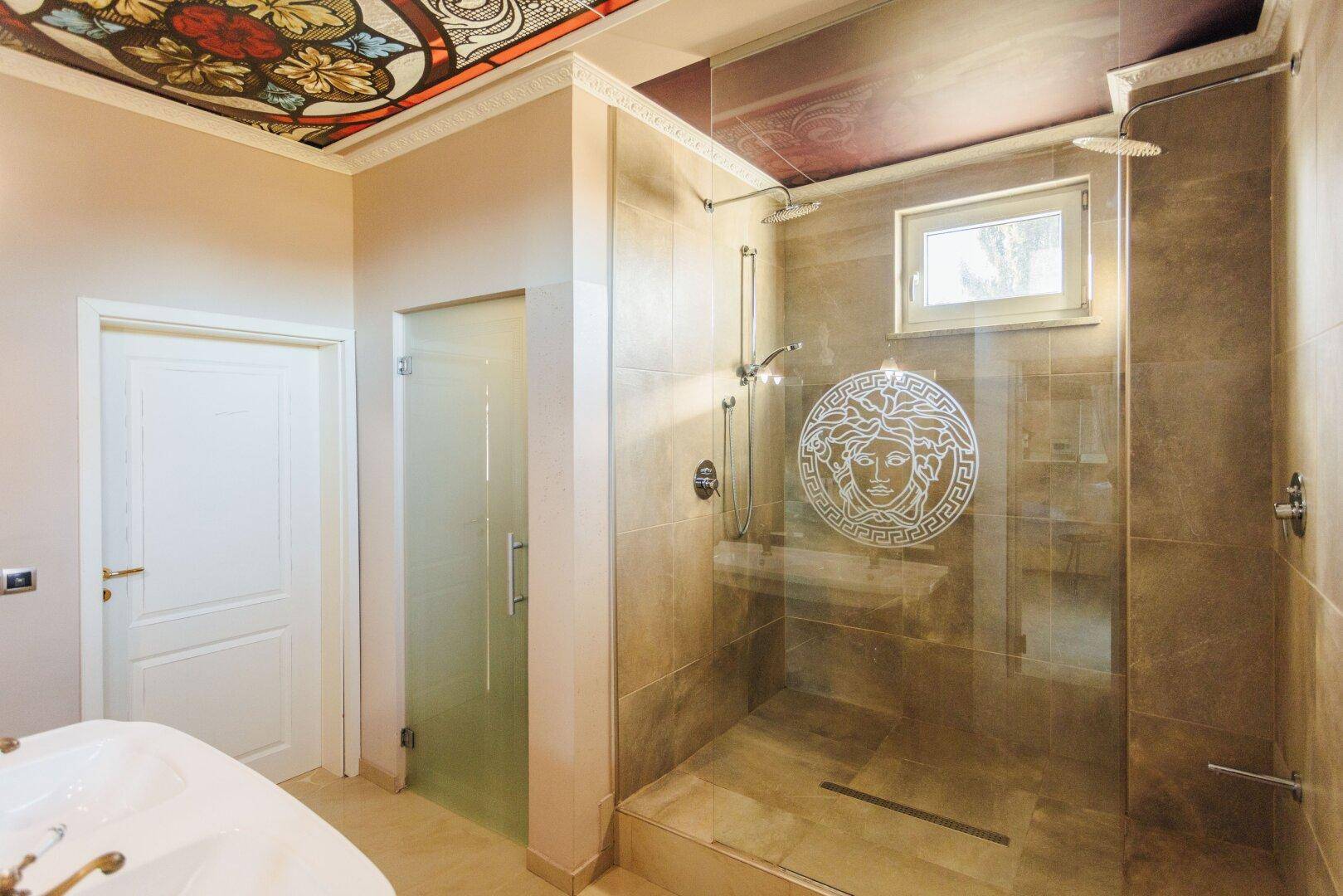 Luxuriöses Badezimmer mit begehbarer Dusche, Badewanne und kunstvoll bemalter Decke.
