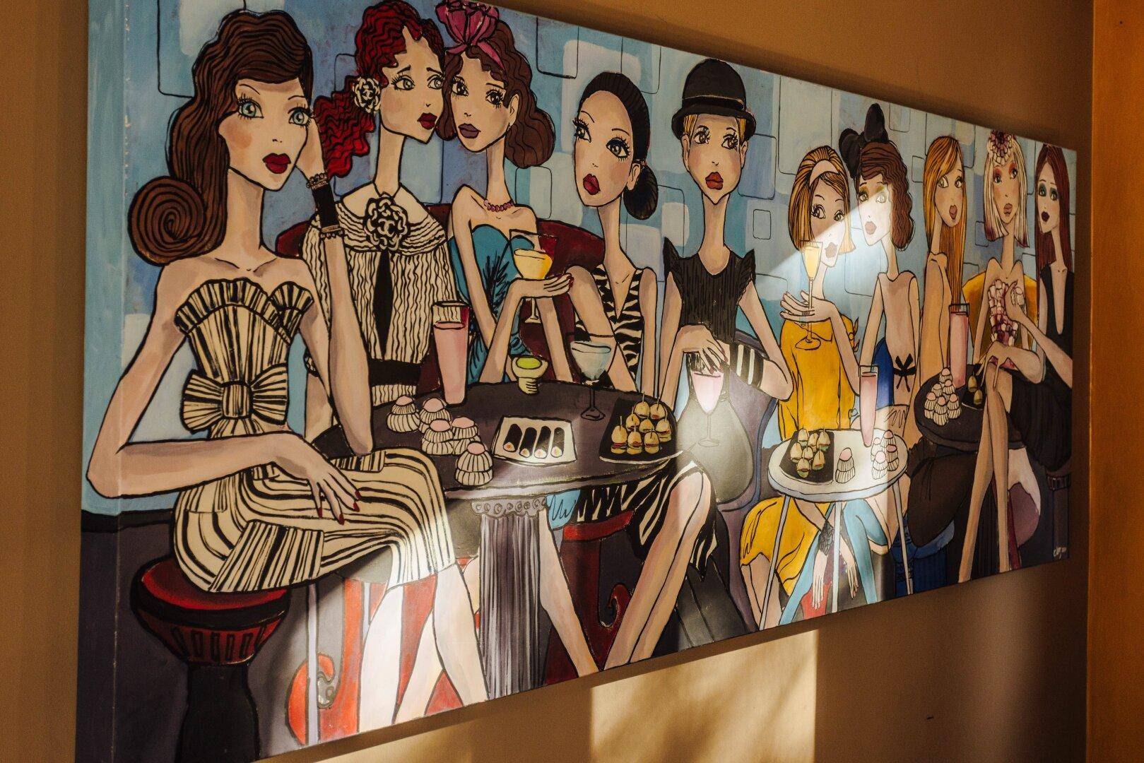 Nahaufnahme eines farbenfrohen Kunstwerks an der Wand, das eine Gruppe von Frauen darstellt.
