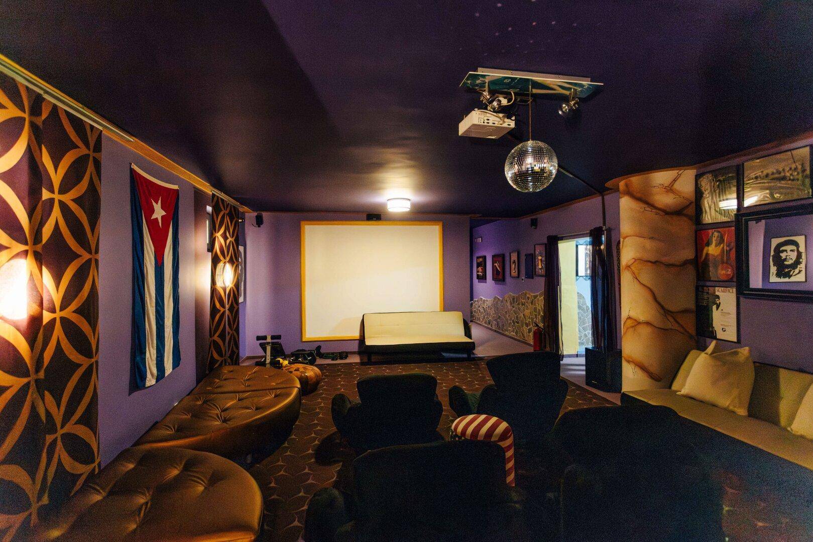 Gemütlicher Medienraum im Keller mit großer Leinwand, Projektor und bequemen Sitzgelegenheiten.