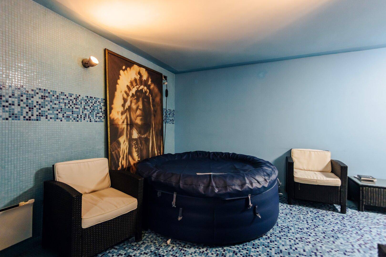 Entspannungsbereich mit Whirlpool, bequemen Sesseln und dekorativem Wandbild.