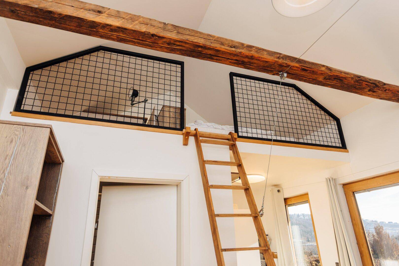 Gemütlicher Schlafbereich im Loft des Gästehauses, erreichbar über eine Holzleiter.