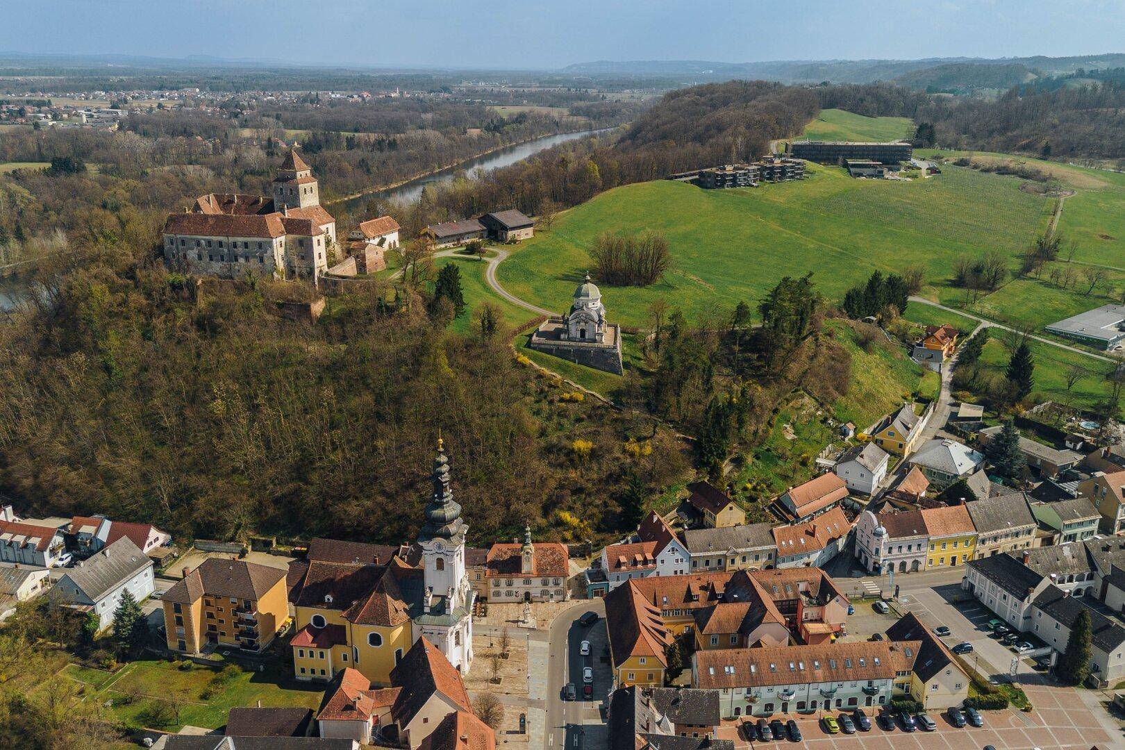 Umfassende Luftaufnahme der Stadt mit Fluss, Burg, Kirche und weitreichender Landschaft.