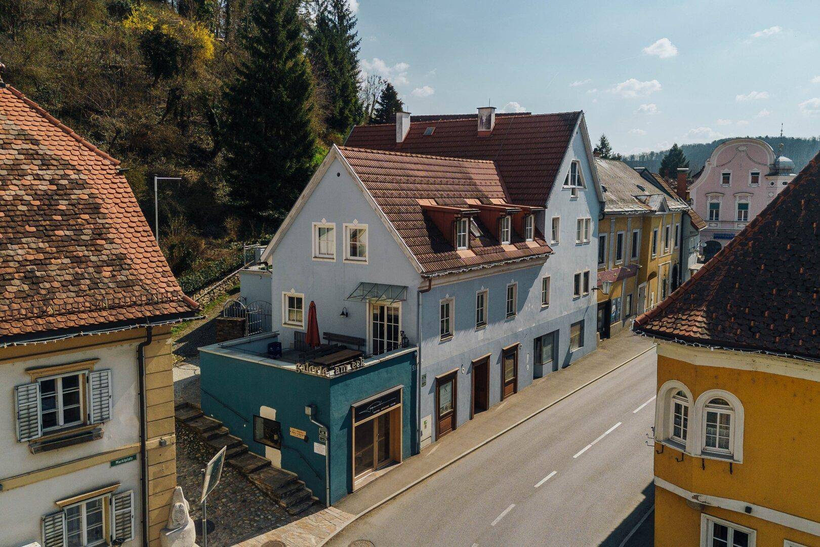 Luftaufnahme des historischen Gebäudes mit rotem Ziegeldach und der umliegenden Altstadt.