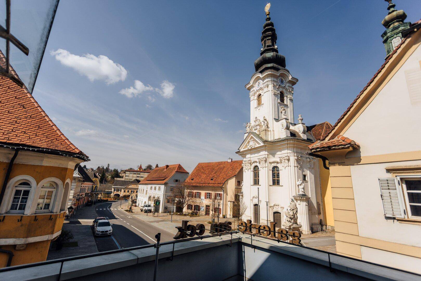 Panoramablick von der Terrasse auf die historische Straße und den imposanten Kirchturm.